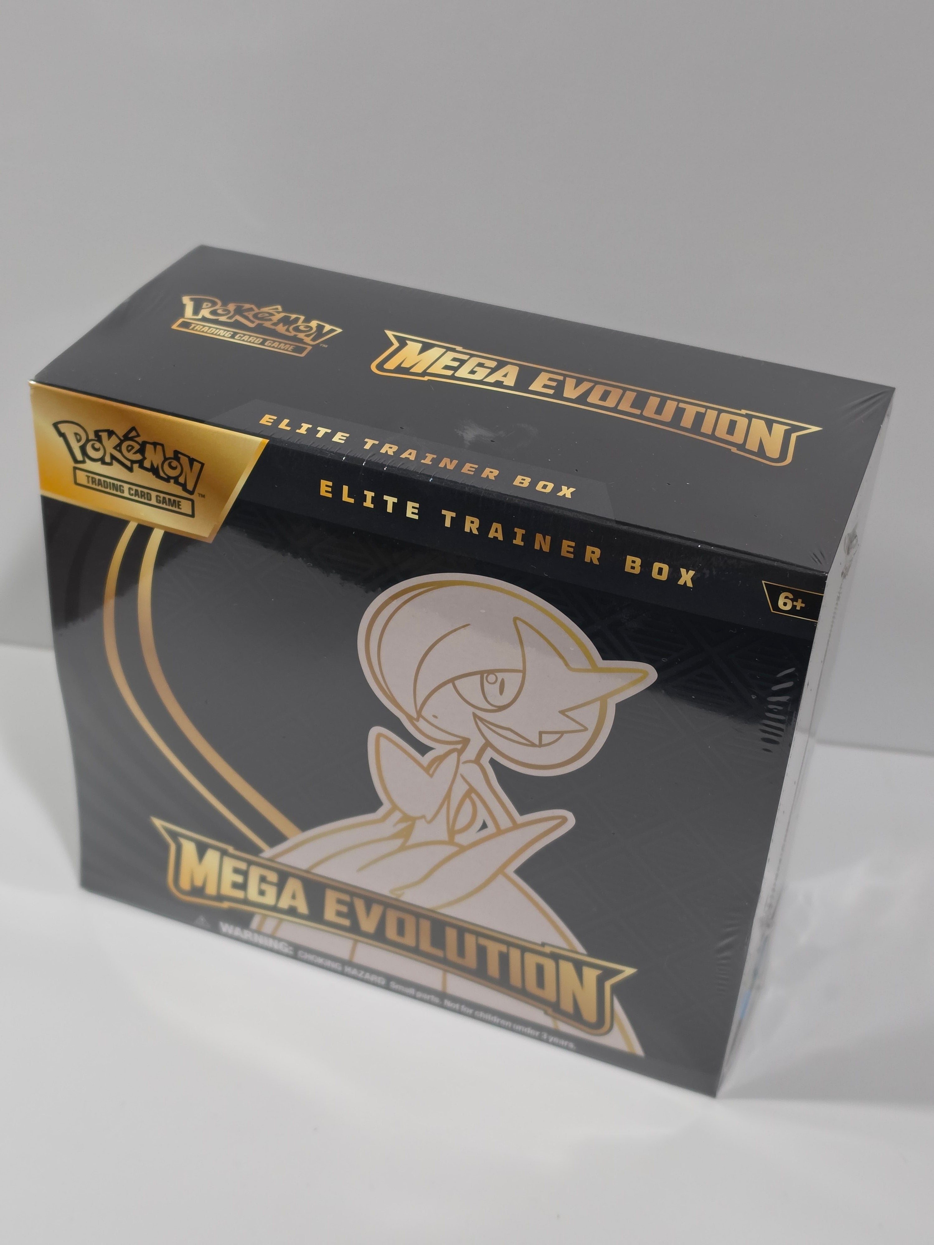 Black and gold trading card box with 'Mega Evolution' branding on a white background